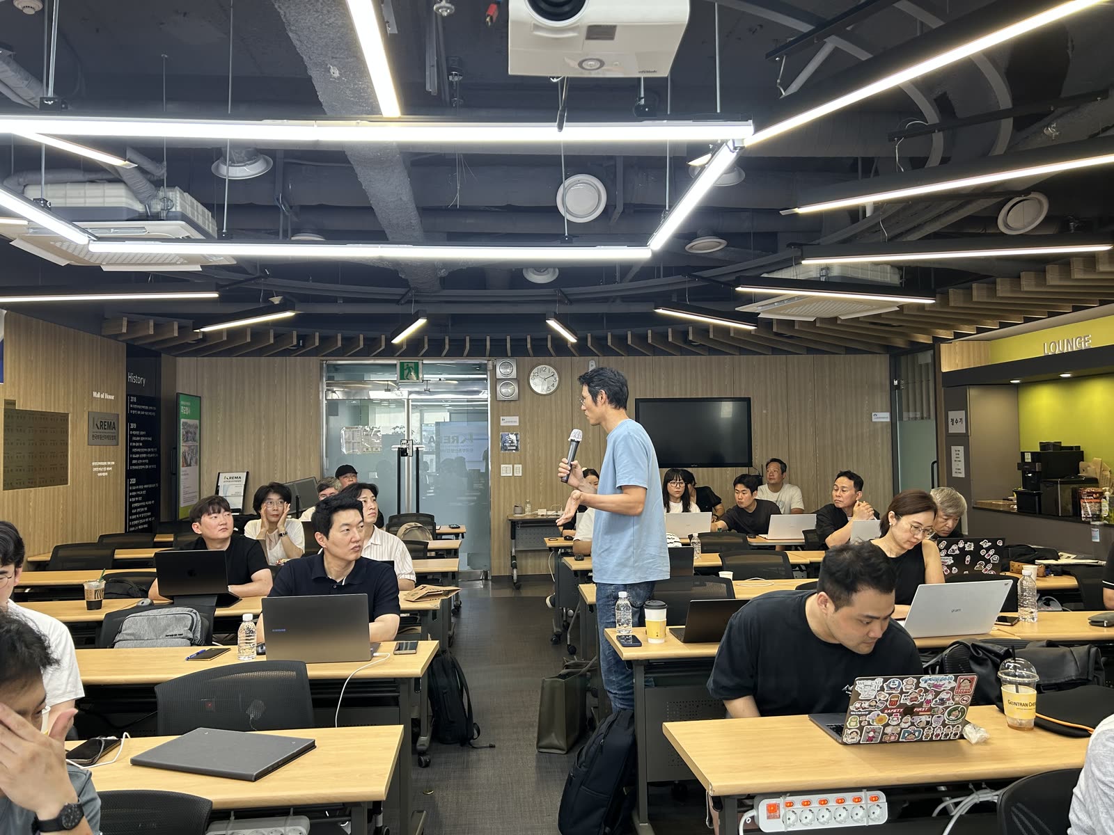 제1회 세미나 현장 — 원재웅 교수(경희대)가 마이크를 들고 발언 중이고 참가자들이 노트북으로 실습하고 있다